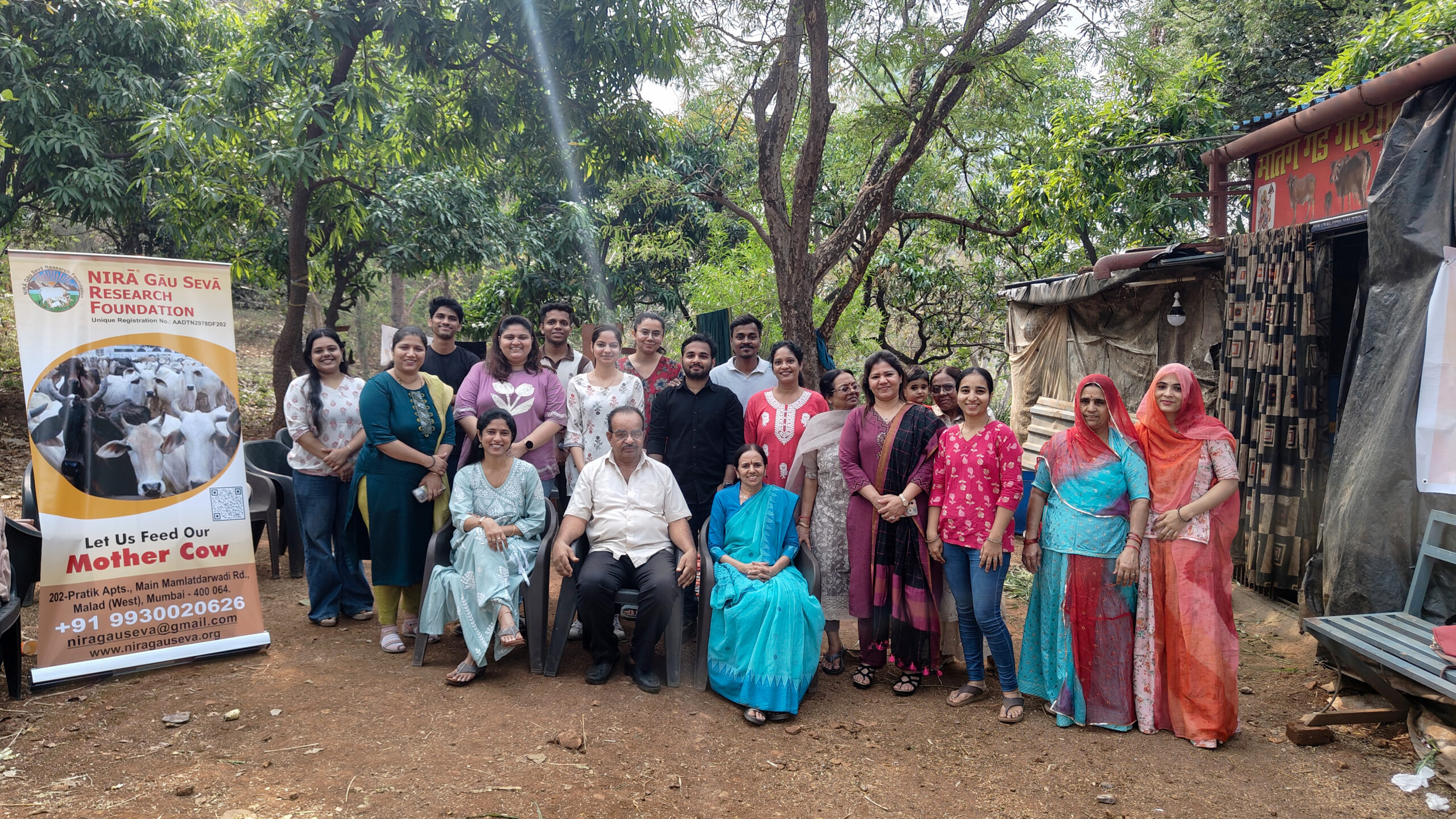 The entire Shivam Autozone team posing with representatives from the Nira Gau Seva Research Foundation at their facility in Malad, Mumbai. A large banner titled "Let Us Feed Our Mother Cow" marks the successful completion of this CSR initiative, aimed at creating a lasting community impact across Maharashtra and Mumbai communities.